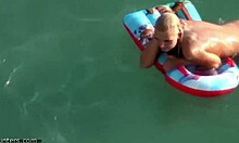 Si blonde dengan punggung buih memamerkan asetnya di dalam air